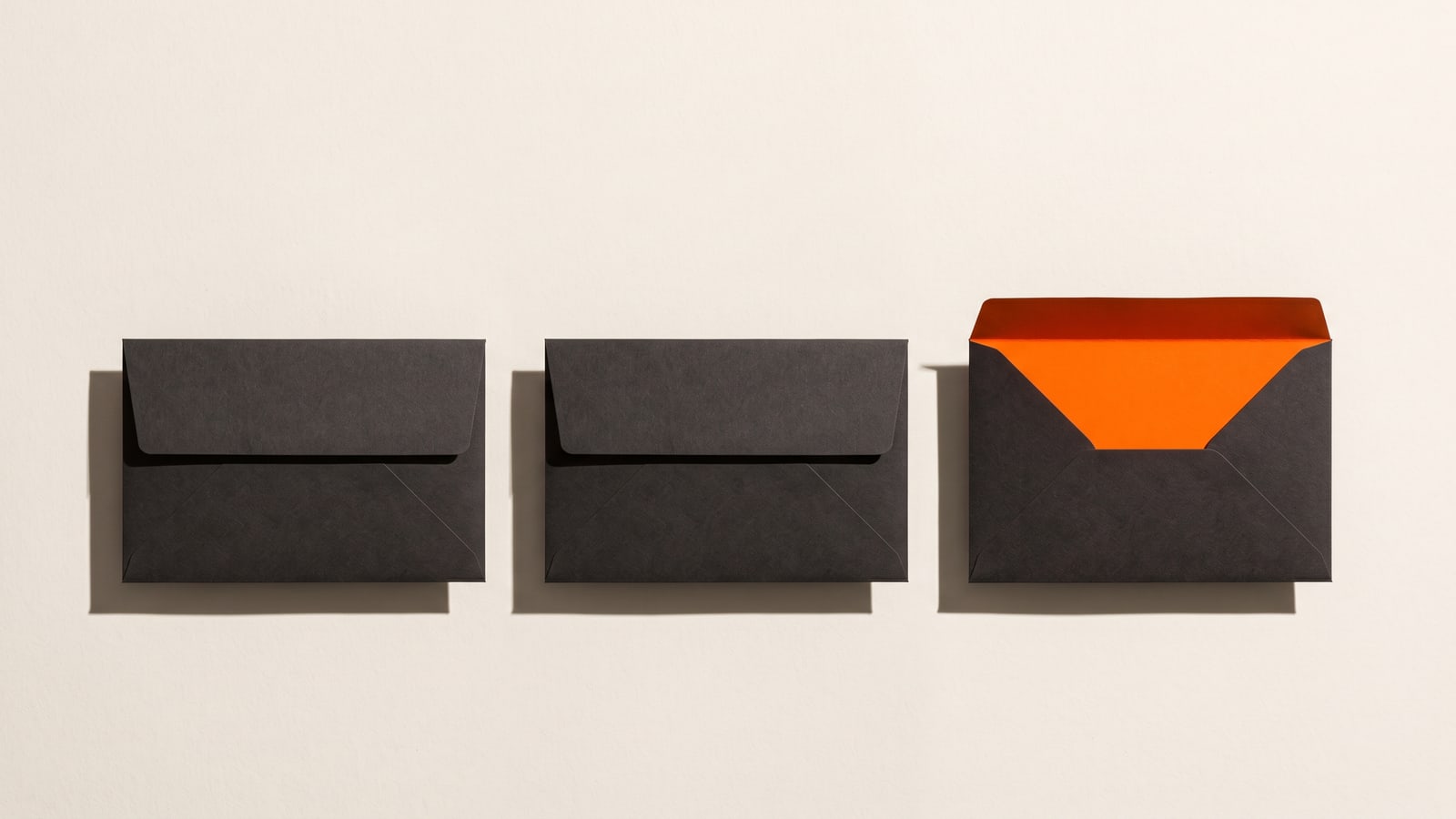 Três envelopes iguais, um deles aberto, sobre como escolher uma agência de branding no Espírito Santo